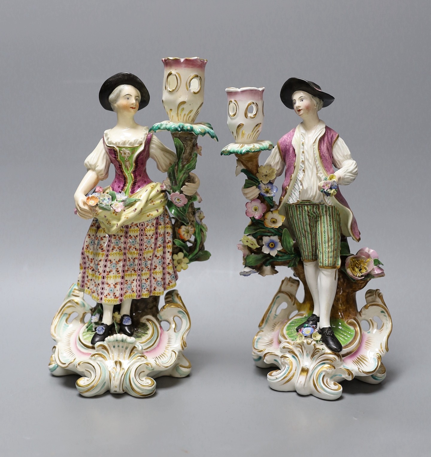 A near pair of Derby candlestick figures, tallest 25.5 cms high